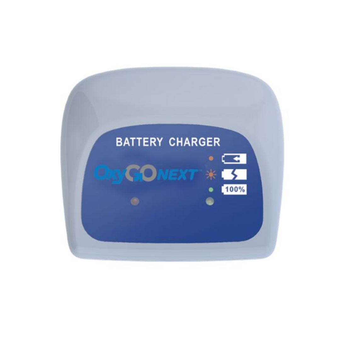 The OxyGo NEXT Desktop Battery Charger is an external charging unit with indicator lights and icons showing battery status and level, designed for oxygen therapy. Background color: white.